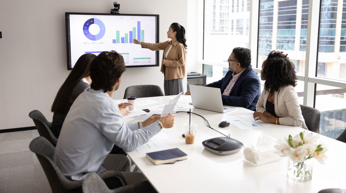 Deux membres d'une équipe comptable d'une PME discutant d'un processus de relance client autour d'un tableau de bord